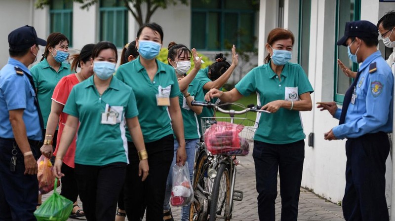 Para pekerja berpamitan kepada pemimpin mereka pada hari terakhir mereka bekerja di pabrik Taiwan Ty Hung di Kota Ho Chi Minh, Taiwan.  (AFP via Getty Images/NHAC NGUYEN)