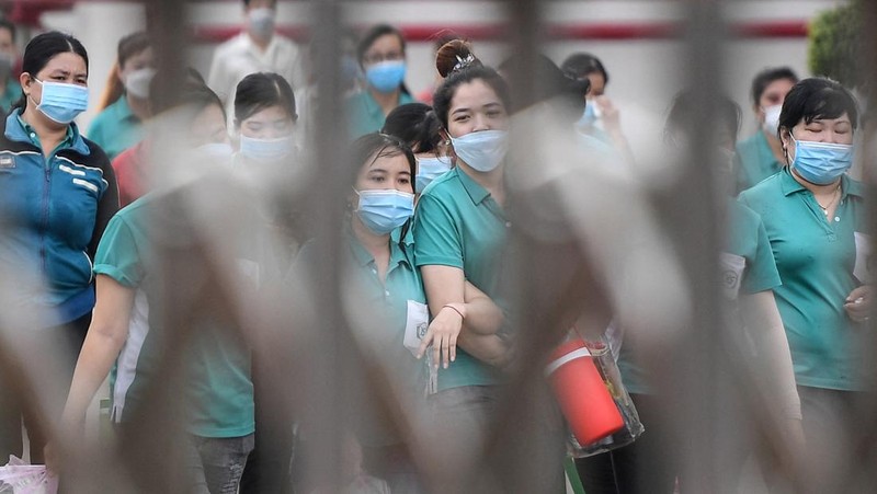 Para pekerja berpamitan kepada pemimpin mereka pada hari terakhir mereka bekerja di pabrik Taiwan Ty Hung di Kota Ho Chi Minh, Taiwan.  (AFP via Getty Images/NHAC NGUYEN)
