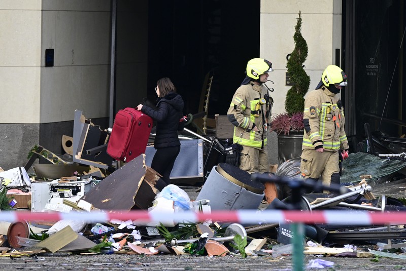 Akuarium Besar Pecah di hotel Radisson Blu, Berlin Petugas mengevakuasi ikan hidup di baskom saat mereka membersihkan puing hotel Radisson Blu setelah akuarium besar yang terletak di lobi hotel meledak di Berlin, Jumat (16/12/2022). Akuarium yang dapat menampung 1.500 ikan tropis dari 80 jenis spesies berbeda dan memiliki tinggi 25 meter dan satu juta liter air itu pecah yang adanya penutupan jalan disekitar lokasi kejadian. (Photo by JOHN MACDOUGALL/AFP via Getty Images)