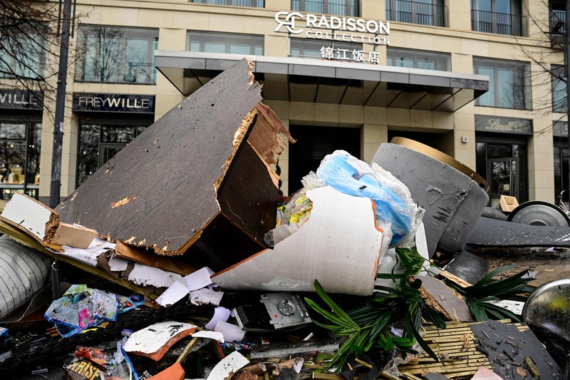 Petugas mengevakuasi ikan hidup di baskom saat mereka membersihkan puing hotel Radisson Blu setelah akuarium besar yang terletak di lobi hotel meledak di Berlin, Jumat (16/12/2022).  Akuarium yang dapat menampung 1.500 ikan tropis dari 80 jenis spesies berbeda dan memiliki tinggi 25 meter dan satu juta liter air itu pecah yang adanya penutupan jalan disekitar lokasi kejadian. (Photo by JOHN MACDOUGALL/AFP via Getty Images)