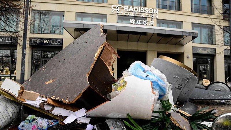 Petugas mengevakuasi ikan hidup di baskom saat mereka membersihkan puing hotel Radisson Blu setelah akuarium besar yang terletak di lobi hotel meledak di Berlin, Jumat (16/12/2022).  Akuarium yang dapat menampung 1.500 ikan tropis dari 80 jenis spesies berbeda dan memiliki tinggi 25 meter dan satu juta liter air itu pecah yang adanya penutupan jalan disekitar lokasi kejadian. (Photo by JOHN MACDOUGALL/AFP via Getty Images)