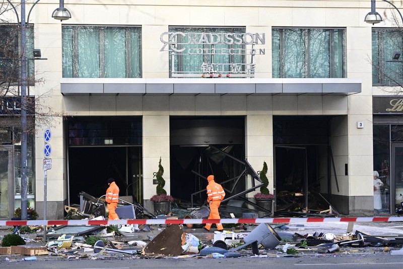 Petugas mengevakuasi ikan hidup di baskom saat mereka membersihkan puing hotel Radisson Blu setelah akuarium besar yang terletak di lobi hotel meledak di Berlin, Jumat (16/12/2022).  Akuarium yang dapat menampung 1.500 ikan tropis dari 80 jenis spesies berbeda dan memiliki tinggi 25 meter dan satu juta liter air itu pecah yang adanya penutupan jalan disekitar lokasi kejadian. (Photo by JOHN MACDOUGALL/AFP via Getty Images)
