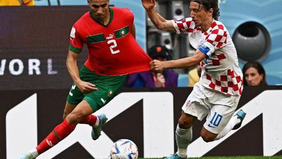 Croatia's midfielder #10 Luka Modric grabs the jersey of Morocco's defender #02 Achraf Hakimi as they fight for the ball during the Qatar 2022 World Cup Group F football match between Morocco and Croatia at the Al-Bayt Stadium in Al Khor, north of Doha on November 23, 2022. (Photo by MANAN VATSYAYANA / AFP)