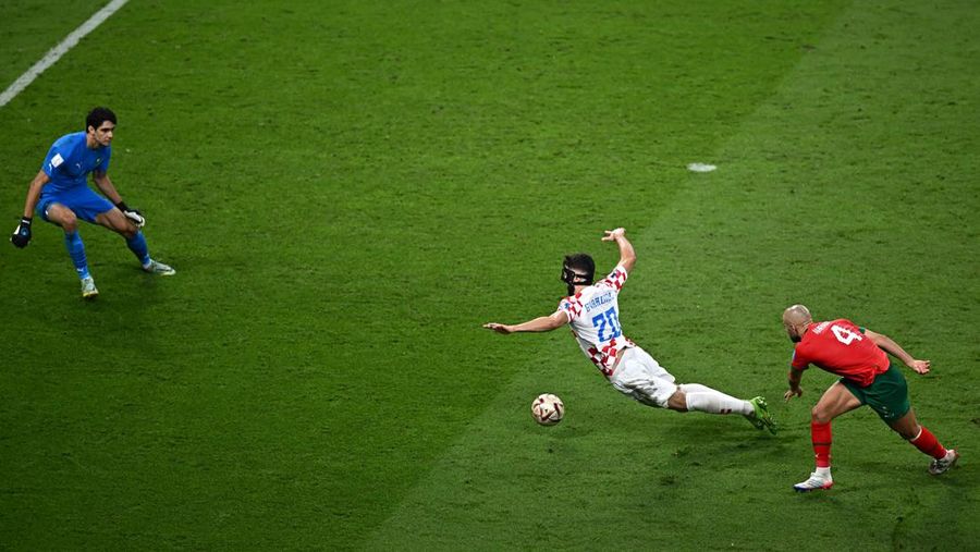 Pemain Maroko Achraf Dari (tengah) mencetak gol pembuka timnya selama pertandingan sepak bola perebutan tempat ketiga Piala Dunia antara Kroasia dan Maroko di Stadion Internasional Khalifa di Doha, Qatar, Sabtu (17/12/2022). Kroasia berhasil mengalahkan Maroko 2-1 pada perebutan posisi ketiga Piala Dunia 2022. Hasil itu menobatkan Kroasia sebagai juara ketiga pada Piala Dunia edisi kali ini.  (AP Photo/Frank Augstein)