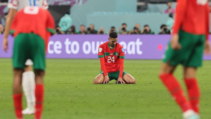 Para pemain Maroko termasuk bek Maroko #24 Badr Benoun (tengah) bereaksi setelah pertandingan play-off perebutan tempat ketiga Piala Dunia Qatar 2022 antara Kroasia dan Maroko di Stadion Internasional Khalifa di Doha, Qatar, Sabtu (17/12/2022). Kroasia berhasil mengalahkan Maroko 2-1 pada perebutan posisi ketiga Piala Dunia 2022. Hasil itu menobatkan Kroasia sebagai juara ketiga pada Piala Dunia edisi kali ini. (Photo by KARIM JAAFAR/AFP via Getty Images)