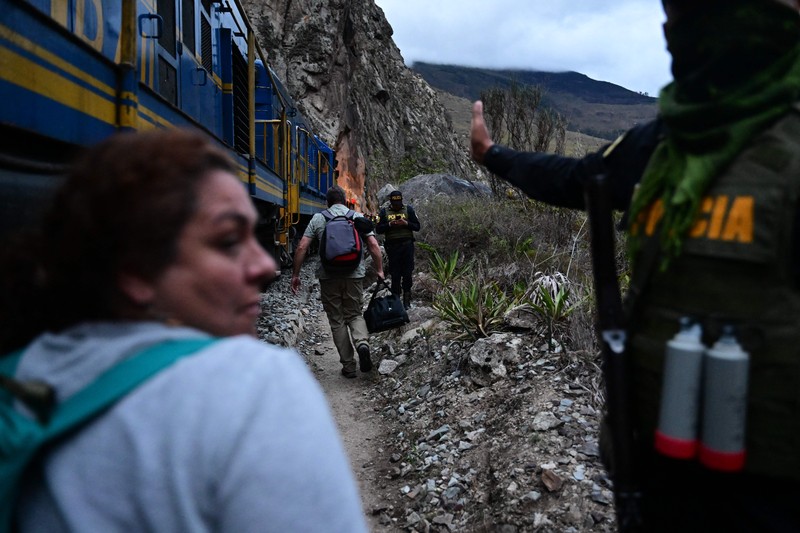 Turis yang terdampar usai mengunjungi benteng Inca di Machu Picchu treck dievakuasi dengan kereta api ke Ollantaytambo, Peru, Sabtu (17/12/2022). Ratusan turis terlantar di Kota Machu Picchu karena akses kereta dihentikan usai Peru mendeklarasikan status darurat menyusul pemakzulan dan penahanan mantan presiden Pedro Castillo pada tengah pekan ini. Kedaruratan ini dipicu krisis politik dan kerusuhan berdarah yang hingga kini sudah menewaskan setidaknya 20 orang dan 340 lainnya luka-luka. (Photo by MARTIN BERNETTI/AFP via Getty Images)