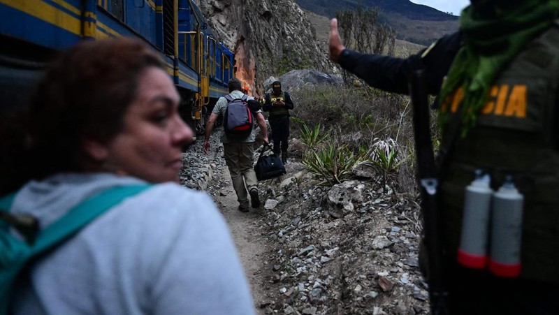 Turis yang terdampar usai mengunjungi benteng Inca di Machu Picchu treck dievakuasi dengan kereta api ke Ollantaytambo, Peru, Sabtu (17/12/2022). Ratusan turis terlantar di Kota Machu Picchu karena akses kereta dihentikan usai Peru mendeklarasikan status darurat menyusul pemakzulan dan penahanan mantan presiden Pedro Castillo pada tengah pekan ini. Kedaruratan ini dipicu krisis politik dan kerusuhan berdarah yang hingga kini sudah menewaskan setidaknya 20 orang dan 340 lainnya luka-luka. (Photo by MARTIN BERNETTI/AFP via Getty Images)