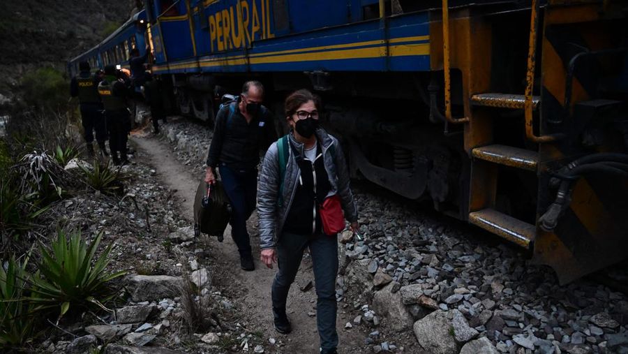Turis yang terdampar usai mengunjungi benteng Inca di Machu Picchu treck dievakuasi dengan kereta api ke Ollantaytambo, Peru, Sabtu (17/12/2022). Ratusan turis terlantar di Kota Machu Picchu karena akses kereta dihentikan usai Peru mendeklarasikan status darurat menyusul pemakzulan dan penahanan mantan presiden Pedro Castillo pada tengah pekan ini. Kedaruratan ini dipicu krisis politik dan kerusuhan berdarah yang hingga kini sudah menewaskan setidaknya 20 orang dan 340 lainnya luka-luka. (Photo by MARTIN BERNETTI/AFP via Getty Images)