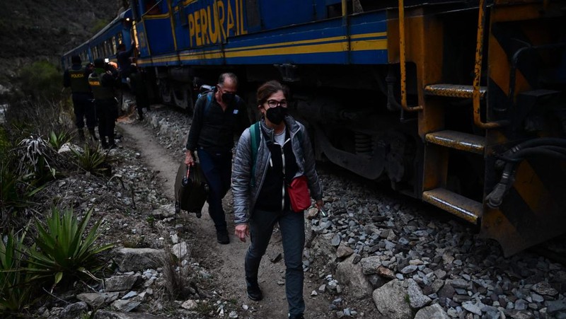 Turis yang terdampar usai mengunjungi benteng Inca di Machu Picchu treck dievakuasi dengan kereta api ke Ollantaytambo, Peru, Sabtu (17/12/2022). Ratusan turis terlantar di Kota Machu Picchu karena akses kereta dihentikan usai Peru mendeklarasikan status darurat menyusul pemakzulan dan penahanan mantan presiden Pedro Castillo pada tengah pekan ini. Kedaruratan ini dipicu krisis politik dan kerusuhan berdarah yang hingga kini sudah menewaskan setidaknya 20 orang dan 340 lainnya luka-luka. (Photo by MARTIN BERNETTI/AFP via Getty Images)