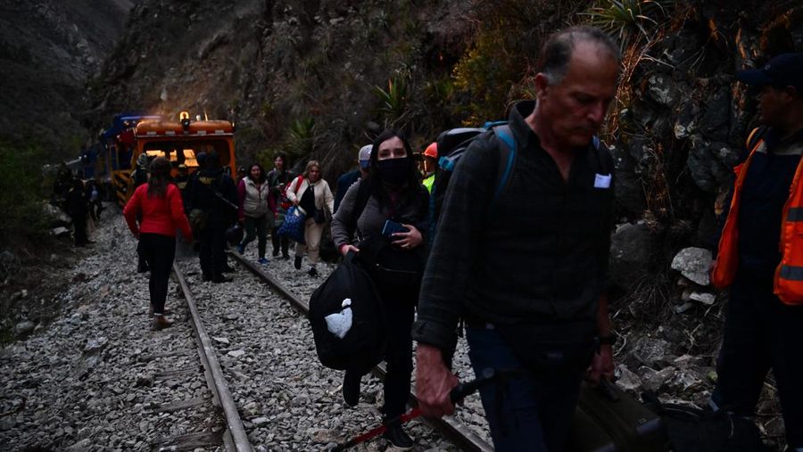 Turis yang terdampar usai mengunjungi benteng Inca di Machu Picchu treck dievakuasi dengan kereta api ke Ollantaytambo, Peru, Sabtu (17/12/2022). Ratusan turis terlantar di Kota Machu Picchu karena akses kereta dihentikan usai Peru mendeklarasikan status darurat menyusul pemakzulan dan penahanan mantan presiden Pedro Castillo pada tengah pekan ini. Kedaruratan ini dipicu krisis politik dan kerusuhan berdarah yang hingga kini sudah menewaskan setidaknya 20 orang dan 340 lainnya luka-luka. (Photo by MARTIN BERNETTI/AFP via Getty Images)