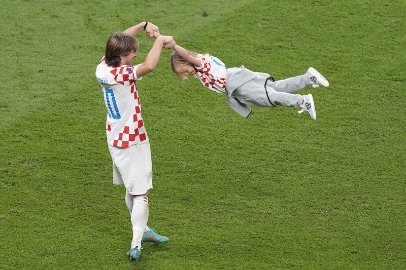 Pemain Kroasia Ante Budimir dan Marcelo Brozovic mengenakan medali saat mereka merayakannya bersama anak-anak di lapangan usai pertandingan sepak bola perebutan tempat ketiga Piala Dunia antara Kroasia dan Maroko Pemain Kroasia Ante Budimir dan Marcelo Brozovic mengenakan medali saat mereka merayakannya bersama anak-anak di lapangan usai pertandingan sepak bola perebutan tempat ketiga Piala Dunia antara Kroasia dan Maroko di Stadion Internasional Khalifa di Doha, Qatar, Sabtu (17/12/2022). Kroasia berhasil mengalahkan Maroko 2-1 pada perebutan posisi ketiga Piala Dunia 2022. Hasil itu menobatkan Kroasia sebagai juara ketiga pada Piala Dunia edisi kali ini. (REUTERS/Bernadett Szabo)
