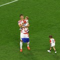 Pemain Kroasia Ante Budimir dan Marcelo Brozovic mengenakan medali saat mereka merayakannya bersama anak-anak di lapangan usai pertandingan sepak bola perebutan tempat ketiga Piala Dunia antara Kroasia dan Maroko di Stadion Internasional Khalifa di D