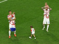 Pemain Kroasia Ante Budimir dan Marcelo Brozovic mengenakan medali saat mereka merayakannya bersama anak-anak di lapangan usai pertandingan sepak bola perebutan tempat ketiga Piala Dunia antara Kroasia dan Maroko di Stadion Internasional Khalifa di D