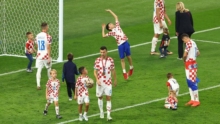 Pemain Kroasia Ante Budimir dan Marcelo Brozovic mengenakan medali saat mereka merayakannya bersama anak-anak di lapangan usai pertandingan sepak bola perebutan tempat ketiga Piala Dunia antara Kroasia dan Maroko di Stadion Internasional Khalifa di Doha, Qatar, Sabtu (17/12/2022). Kroasia berhasil mengalahkan Maroko 2-1 pada perebutan posisi ketiga Piala Dunia 2022. Hasil itu menobatkan Kroasia sebagai juara ketiga pada Piala Dunia edisi kali ini. (REUTERS/Bernadett Szabo)