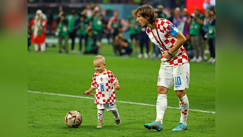 Pemain Kroasia Ante Budimir dan Marcelo Brozovic mengenakan medali saat mereka merayakannya bersama anak-anak di lapangan usai pertandingan sepak bola perebutan tempat ketiga Piala Dunia antara Kroasia dan Maroko di Stadion Internasional Khalifa di Doha, Qatar, Sabtu (17/12/2022). Kroasia berhasil mengalahkan Maroko 2-1 pada perebutan posisi ketiga Piala Dunia 2022. Hasil itu menobatkan Kroasia sebagai juara ketiga pada Piala Dunia edisi kali ini. (REUTERS/Bernadett Szabo)