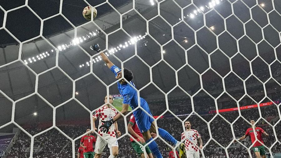 Pemain Maroko Achraf Dari (tengah) mencetak gol pembuka timnya selama pertandingan sepak bola perebutan tempat ketiga Piala Dunia antara Kroasia dan Maroko di Stadion Internasional Khalifa di Doha, Qatar, Sabtu (17/12/2022). Kroasia berhasil mengalahkan Maroko 2-1 pada perebutan posisi ketiga Piala Dunia 2022. Hasil itu menobatkan Kroasia sebagai juara ketiga pada Piala Dunia edisi kali ini.  (AP Photo/Frank Augstein)