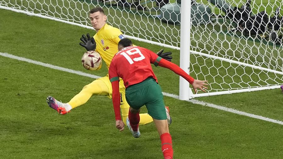 Pemain Maroko Achraf Dari (tengah) mencetak gol pembuka timnya selama pertandingan sepak bola perebutan tempat ketiga Piala Dunia antara Kroasia dan Maroko di Stadion Internasional Khalifa di Doha, Qatar, Sabtu (17/12/2022). Kroasia berhasil mengalahkan Maroko 2-1 pada perebutan posisi ketiga Piala Dunia 2022. Hasil itu menobatkan Kroasia sebagai juara ketiga pada Piala Dunia edisi kali ini.  (AP Photo/Frank Augstein)