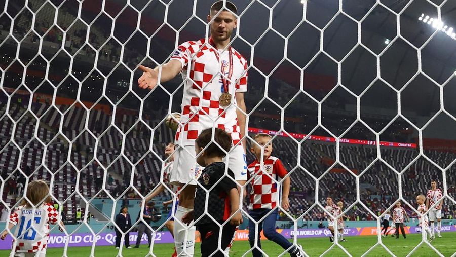 Pemain Kroasia Ante Budimir dan Marcelo Brozovic mengenakan medali saat mereka merayakannya bersama anak-anak di lapangan usai pertandingan sepak bola perebutan tempat ketiga Piala Dunia antara Kroasia dan Maroko di Stadion Internasional Khalifa di Doha, Qatar, Sabtu (17/12/2022). Kroasia berhasil mengalahkan Maroko 2-1 pada perebutan posisi ketiga Piala Dunia 2022. Hasil itu menobatkan Kroasia sebagai juara ketiga pada Piala Dunia edisi kali ini. (REUTERS/Bernadett Szabo)
