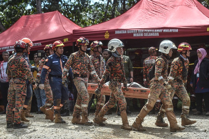 Tim penyelamat bekerja selama operasi penyelamatan dan evakuasi pasca tanah longsor di perkemahan di Batang Kali, Selangor, Malaysia, Sabtu (17/12/2022). Sebanyak 24 orang tewas setelah tragedi tanah longsor di bumi perkemahan yang terletak di pertanian organik Gohtong Jaya, dekat kota Batang Kali, Malaysia. (REUTERS/Hasnoor Hussain)