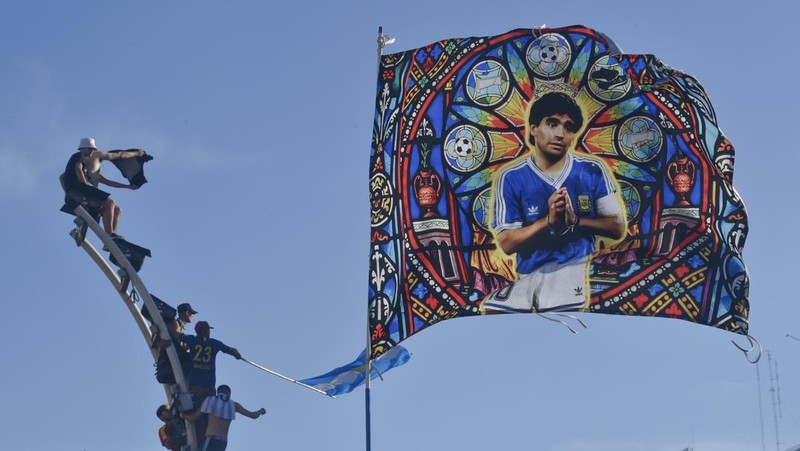 Suasana para fans Argentina dengan spanduk Diego Maradona berkumpul merayakan kemenangan negaranya usai pertandingan sepak bola final Piala Dunia Qatar 2022 antara Argentina dan Prancis di Buenos Aires, Argentina Minggu (18/12/2022). Argentina menjadi juara Piala Dunia 2022 setelah menang adu penalti atas Prancis 4-2. (REUTERS/Agustin Marcarian)