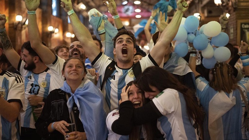Suasana para fans Argentina dengan spanduk Diego Maradona berkumpul merayakan kemenangan negaranya usai pertandingan sepak bola final Piala Dunia Qatar 2022 antara Argentina dan Prancis di Buenos Aires, Argentina Minggu (18/12/2022). Argentina menjadi juara Piala Dunia 2022 setelah menang adu penalti atas Prancis 4-2. (REUTERS/Agustin Marcarian)