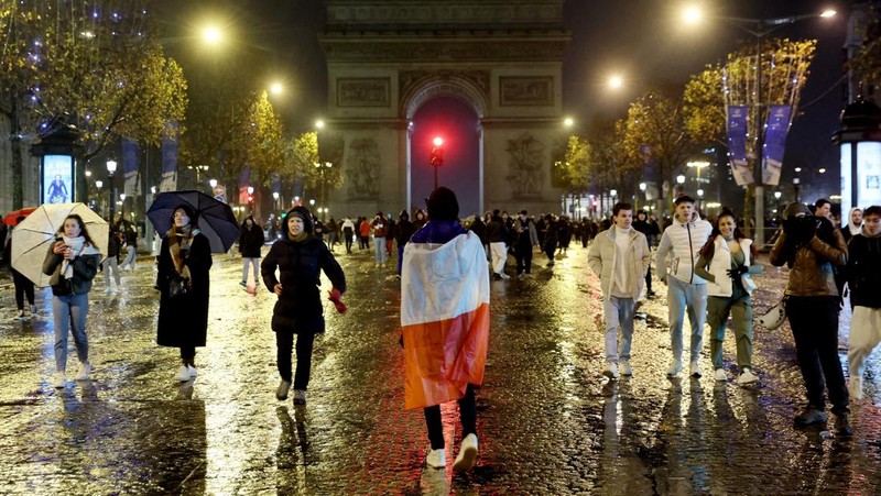 Seorang petugas polisi menendang seseorang setelah pertandingan final sepak bola Piala Dunia antara Argentina dan Prancis di jalan Champs-Elysees, Paris, Minggu (18/12/2022). Argentina telah memenangkan Piala Dunia dengan mengalahkan Prancis 4-2 dalam adu penalti di final. (AP Photo/Thibault Camus)