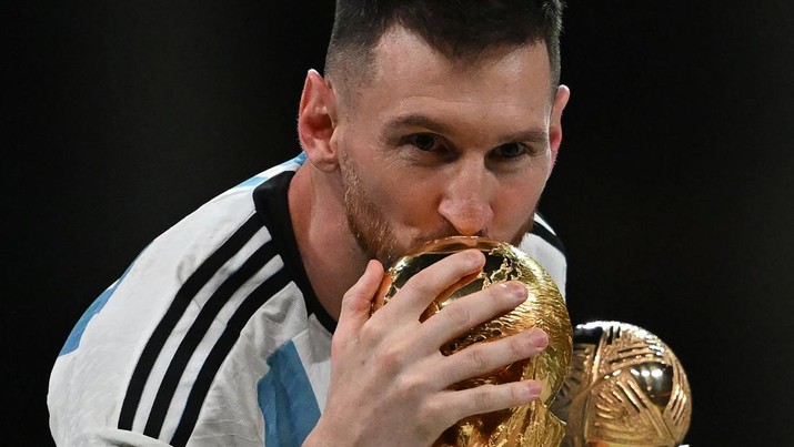 Kapten dan penyerang Argentina #10 Lionel Messi mencium Trofi Piala Dunia FIFA selama upacara trofi setelah Argentina memenangkan pertandingan sepak bola final Piala Dunia Qatar 2022 antara Argentina dan Prancis Kapten dan penyerang Argentina #10 Lionel Messi mencium Trofi Piala Dunia FIFA selama upacara trofi setelah Argentina memenangkan pertandingan sepak bola final Piala Dunia Qatar 2022 antara Argentina dan Prancis di Stadion Lusail di Lusail, utara Doha, Qatar, Minggu (18/12/2022). Argentina menjadi juara Piala Dunia 2022 setelah menang adu penalti atas Prancis 4-2. (Photo by PAUL ELLIS/AFP via Getty Images)