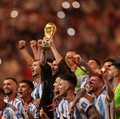 Kapten dan penyerang Argentina #10 Lionel Messi mengangkat Trofi Piala Dunia FIFA selama upacara pemberian trofi usai Argentina memenangkan pertandingan sepak bola final Piala Dunia Qatar 2022 antara Argentina dan Prancis di Stadion Lusail di Lusail,