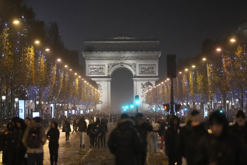 Seorang petugas polisi menendang seseorang setelah pertandingan final sepak bola Piala Dunia antara Argentina dan Prancis di jalan Champs-Elysees, Paris, Minggu (18/12/2022). Argentina telah memenangkan Piala Dunia dengan mengalahkan Prancis 4-2 dalam adu penalti di final. (AP Photo/Thibault Camus)