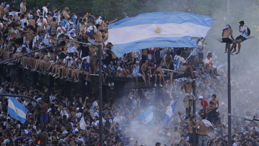 Penggemar sepak bola Argentina merayakan kemenangan tim mereka di Piala Dunia atas Prancis di Buenos Aires, Argentina, Minggu (18/12/2022). Argentina menjadi juara Piala Dunia 2022 setelah menang adu penalti atas Prancis 4-2.(AP Photo/Matilde Campodonico)