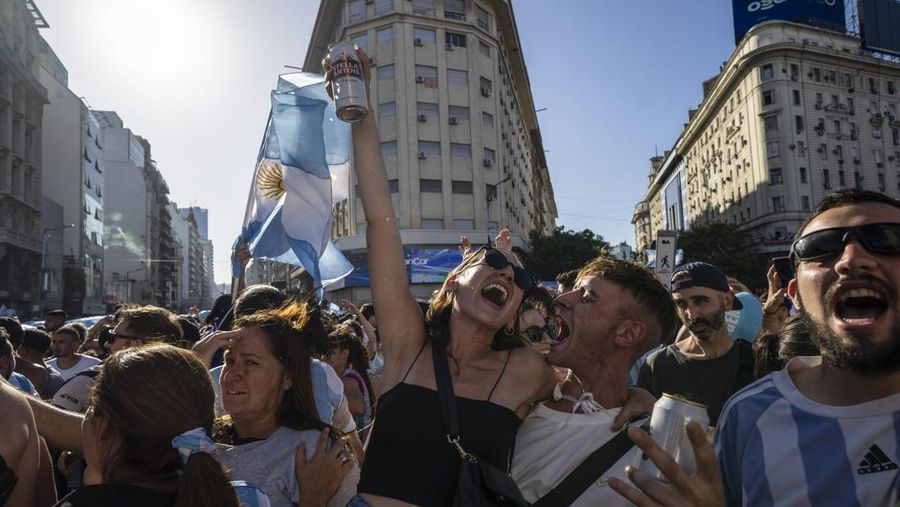 Suasana para fans Argentina dengan spanduk Diego Maradona berkumpul merayakan kemenangan negaranya usai pertandingan sepak bola final Piala Dunia Qatar 2022 antara Argentina dan Prancis di Buenos Aires, Argentina Minggu (18/12/2022). Argentina menjadi juara Piala Dunia 2022 setelah menang adu penalti atas Prancis 4-2. (REUTERS/Agustin Marcarian)