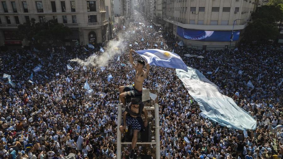 Suasana para fans Argentina dengan spanduk Diego Maradona berkumpul merayakan kemenangan negaranya usai pertandingan sepak bola final Piala Dunia Qatar 2022 antara Argentina dan Prancis di Buenos Aires, Argentina Minggu (18/12/2022). Argentina menjadi juara Piala Dunia 2022 setelah menang adu penalti atas Prancis 4-2. (REUTERS/Agustin Marcarian)