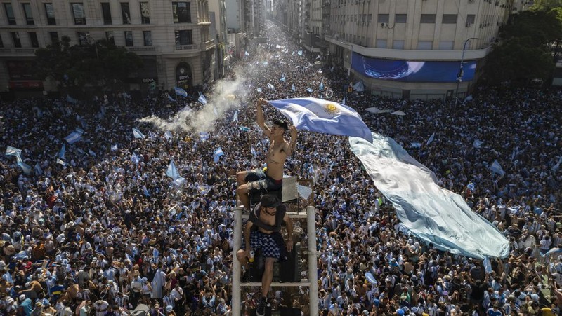 Suasana para fans Argentina dengan spanduk Diego Maradona berkumpul merayakan kemenangan negaranya usai pertandingan sepak bola final Piala Dunia Qatar 2022 antara Argentina dan Prancis di Buenos Aires, Argentina Minggu (18/12/2022). Argentina menjadi juara Piala Dunia 2022 setelah menang adu penalti atas Prancis 4-2. (REUTERS/Agustin Marcarian)