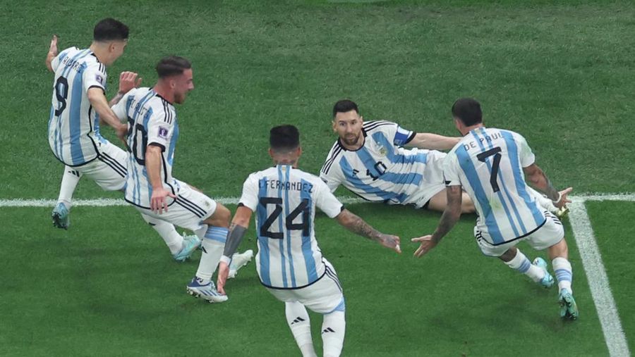 Penyerang #10 Argentina Lionel Messi merayakan dengan rekan setimnya setelah mencetak gol pertama timnya dari titik penalti pada pertandingan final sepak bola Piala Dunia Qatar 2022 antara Argentina dan Prancis di Stadion Lusail di Lusail, utara Doha, Qatar, Minggu (18/12/2022). Argentina menjadi juara Piala Dunia 2022 setelah menang adu penalti atas Prancis 4-2. (Photo by GIUSEPPE CACACE/AFP via Getty Images)
