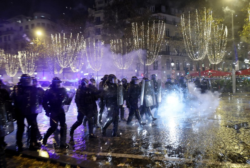 Seorang petugas polisi menendang seseorang setelah pertandingan final sepak bola Piala Dunia antara Argentina dan Prancis di jalan Champs-Elysees, Paris Seorang petugas polisi menendang seseorang setelah pertandingan final sepak bola Piala Dunia antara Argentina dan Prancis di jalan Champs-Elysees, Paris, Minggu (18/12/2022). Argentina telah memenangkan Piala Dunia dengan mengalahkan Prancis 4-2 dalam adu penalti di final. (AP Photo/Thibault Camus)