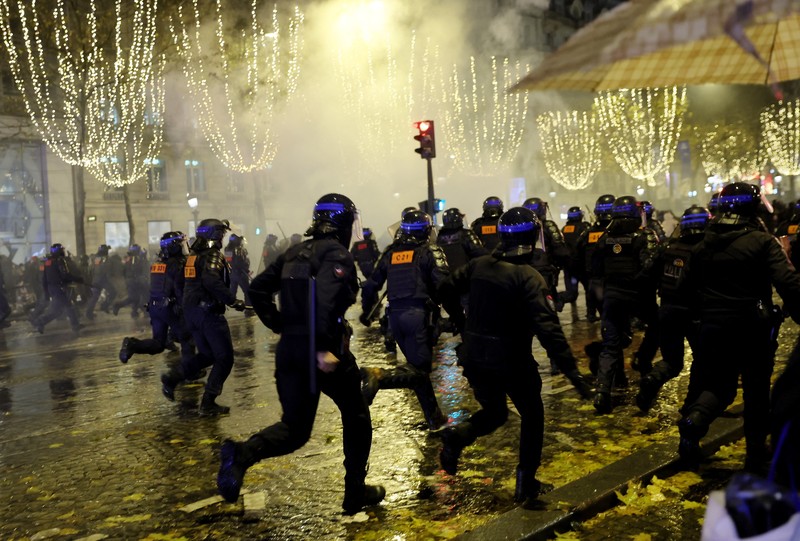 Seorang petugas polisi menendang seseorang setelah pertandingan final sepak bola Piala Dunia antara Argentina dan Prancis di jalan Champs-Elysees, Paris Seorang petugas polisi menendang seseorang setelah pertandingan final sepak bola Piala Dunia antara Argentina dan Prancis di jalan Champs-Elysees, Paris, Minggu (18/12/2022). Argentina telah memenangkan Piala Dunia dengan mengalahkan Prancis 4-2 dalam adu penalti di final. (AP Photo/Thibault Camus)