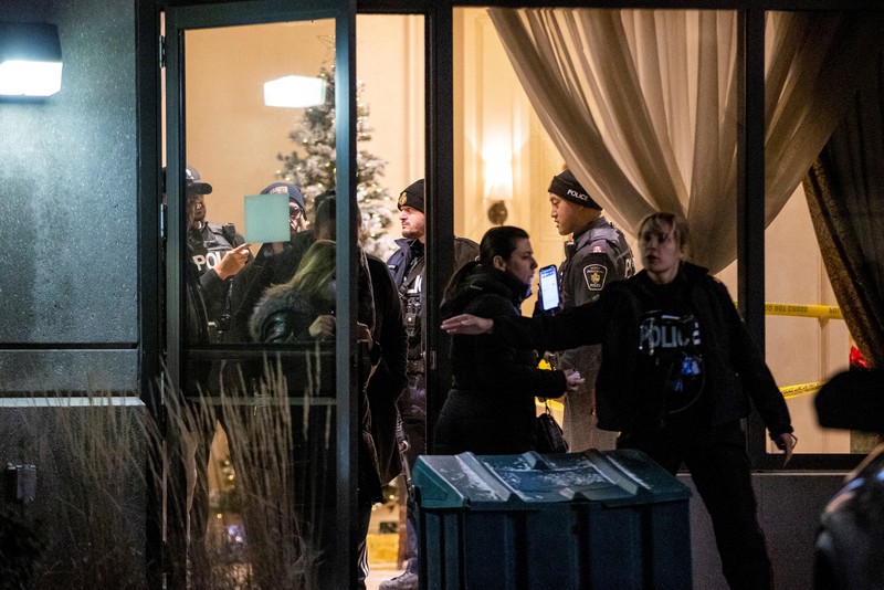 Seorang petugas polisi berjalan dengan senjata setelah penembakan massal yang fatal di sebuah gedung kondominium di pinggiran kota Toronto Vaughan, Ontario, Kanada 19 Desember 2022. (REUTERS/Carlos Osorio)