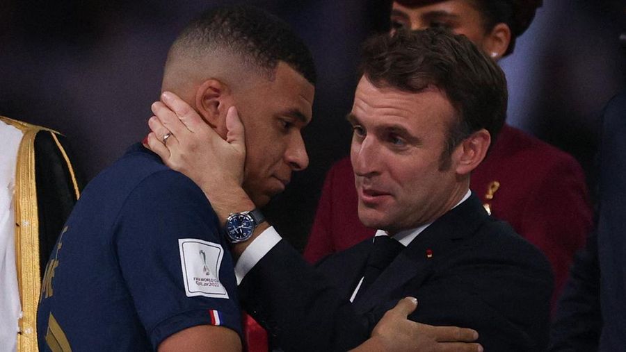 Presiden Prancis Emmanuel Macron (kanan) menyerahkan penghargaan Sepatu Emas FIFA kepada penyerang #10 Prancis Kylian Mbappe (kiri) selama upacara trofi pada akhir pertandingan sepak bola final Piala Dunia Qatar 2022 antara Argentina dan Prancis di Stadion Lusail di Lusail, utara Doha, Qatar, Minggu (18/12/2022). Argentina menjadi juara Piala Dunia 2022 setelah menang adu penalti atas Prancis 4-2. (Photo by ADRIAN DENNIS/AFP via Getty Images)