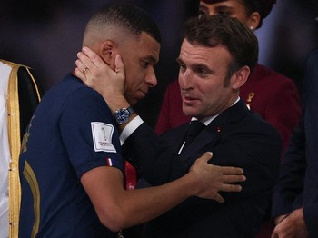 Presiden Prancis Emmanuel Macron (kanan) menyerahkan penghargaan Sepatu Emas FIFA kepada penyerang #10 Prancis Kylian Mbappe (kiri) selama upacara trofi pada akhir pertandingan sepak bola final Piala Dunia Qatar 2022 antara Argentina dan Prancis di S