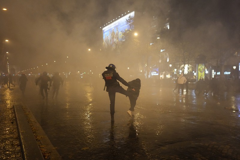 Seorang petugas polisi menendang seseorang setelah pertandingan final sepak bola Piala Dunia antara Argentina dan Prancis di jalan Champs-Elysees, Paris Seorang petugas polisi menendang seseorang setelah pertandingan final sepak bola Piala Dunia antara Argentina dan Prancis di jalan Champs-Elysees, Paris, Minggu (18/12/2022). Argentina telah memenangkan Piala Dunia dengan mengalahkan Prancis 4-2 dalam adu penalti di final. (AP Photo/Thibault Camus)