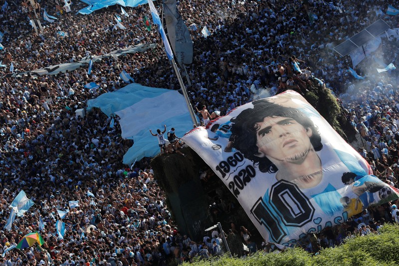 Suasana para fans Argentina dengan spanduk Diego Maradona berkumpul merayakan kemenangan negaranya usai pertandingan sepak bola final Piala Dunia Qatar 2022 antara Argentina dan Prancis di Buenos Aires, Argentina Suasana para fans Argentina dengan spanduk Diego Maradona berkumpul merayakan kemenangan negaranya usai pertandingan sepak bola final Piala Dunia Qatar 2022 antara Argentina dan Prancis di Buenos Aires, Argentina Minggu (18/12/2022). Argentina menjadi juara Piala Dunia 2022 setelah menang adu penalti atas Prancis 4-2. (REUTERS/Agustin Marcarian)