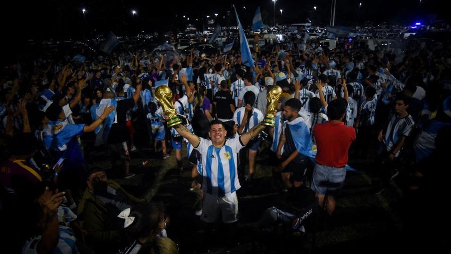 Lionel Messi dari Argentina (Kiri) dan Lionel Scaloni (Kanan) memegang Piala Dunia FIFA saat kedatangan tim sepak bola nasional pria Argentina setelah memenangkan Piala Dunia FIFA Qatar 2022 pada 20 Desember 2022 di Buenos Aires, Argentina. (Marcelo Endelli/Getty Images)