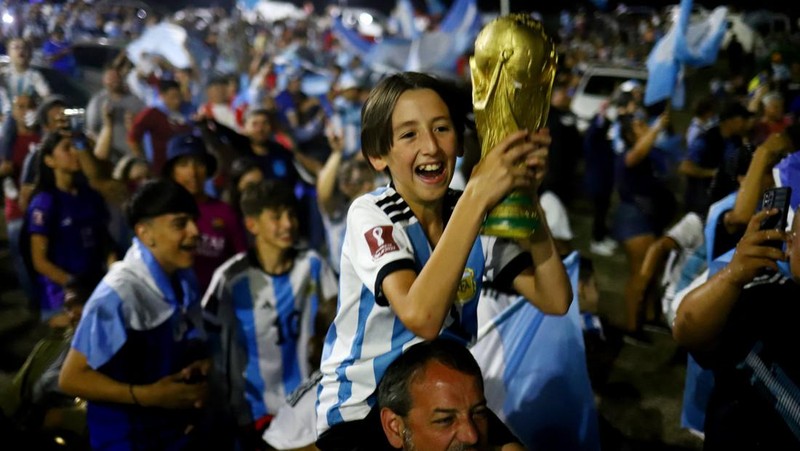Lionel Messi dari Argentina (Kiri) dan Lionel Scaloni (Kanan) memegang Piala Dunia FIFA saat kedatangan tim sepak bola nasional pria Argentina setelah memenangkan Piala Dunia FIFA Qatar 2022 pada 20 Desember 2022 di Buenos Aires, Argentina. (Marcelo Endelli/Getty Images)