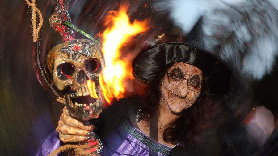 30 April 2022, Saxony-Anhalt, Schierke: In a witch costume a visitor celebrates the Walpurgis festival in Schierke. The largest Walpurgis festival in the Harz Mountains was held here on the night of May 1. Several thousand visitors celebrated partly also in the witch and devil costume. At Walpurgis, the winter is traditionally driven away symbolically. Photo: Matthias Bein/dpa (Photo by Matthias Bein/picture alliance via Getty Images)