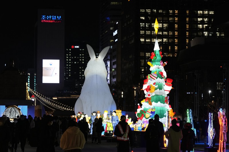 Seorang pengunjung mengambil foto lentera raksasa yang bersinar untuk perayaan Tahun Kelinci 2023 mendatang selama Festival Lentera di Lapangan Gwanghwamun di Seoul, Korea Selatan, Senin, 19 Desember 2022. Seorang pengunjung mengambil foto lentera raksasa yang bersinar untuk perayaan Tahun Kelinci 2023 mendatang selama Festival Lentera di Lapangan Gwanghwamun di Seoul, Korea Selatan, Senin, 19 Desember 2022. Festival ini akan berlangsung dari 19 Desember hingga Desember 31. (AP Photo/Ahn Young-joon)
