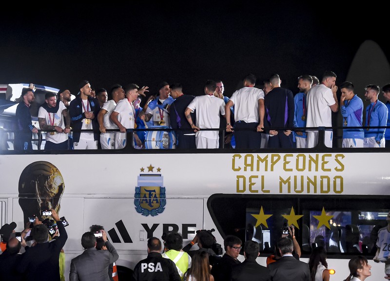 Lionel Messi dari Argentina (Kiri) dan Lionel Scaloni (Kanan) memegang Piala Dunia FIFA saat kedatangan tim sepak bola nasional pria Argentina setelah memenangkan Piala Dunia FIFA Qatar 2022 pada 20 Desember 2022 di Buenos Aires, Argentina. (Marcelo Endelli/Getty Images)
