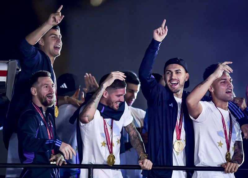 Lionel Messi dari Argentina (Kiri) dan Lionel Scaloni (Kanan) memegang Piala Dunia FIFA saat kedatangan tim sepak bola nasional pria Argentina setelah memenangkan Piala Dunia FIFA Qatar 2022 pada 20 Desember 2022 di Buenos Aires, Argentina. (Marcelo Endelli/Getty Images)