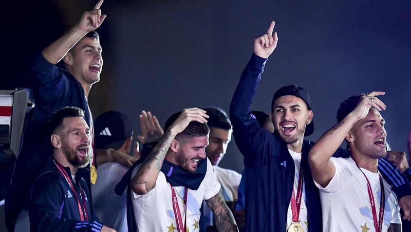 Lionel Messi dari Argentina (Kiri) dan Lionel Scaloni (Kanan) memegang Piala Dunia FIFA saat kedatangan tim sepak bola nasional pria Argentina setelah memenangkan Piala Dunia FIFA Qatar 2022 pada 20 Desember 2022 di Buenos Aires, Argentina. (Marcelo Endelli/Getty Images)