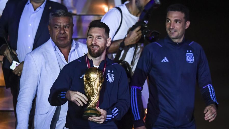 Lionel Messi dari Argentina (Kiri) dan Lionel Scaloni (Kanan) memegang Piala Dunia FIFA saat kedatangan tim sepak bola nasional pria Argentina setelah memenangkan Piala Dunia FIFA Qatar 2022 pada 20 Desember 2022 di Buenos Aires, Argentina. (Marcelo Endelli/Getty Images)