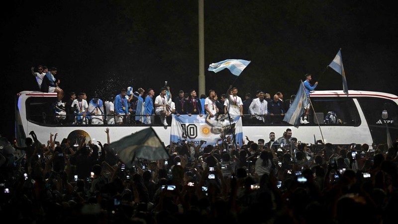 Lionel Messi dari Argentina (Kiri) dan Lionel Scaloni (Kanan) memegang Piala Dunia FIFA saat kedatangan tim sepak bola nasional pria Argentina setelah memenangkan Piala Dunia FIFA Qatar 2022 pada 20 Desember 2022 di Buenos Aires, Argentina. (Marcelo Endelli/Getty Images)